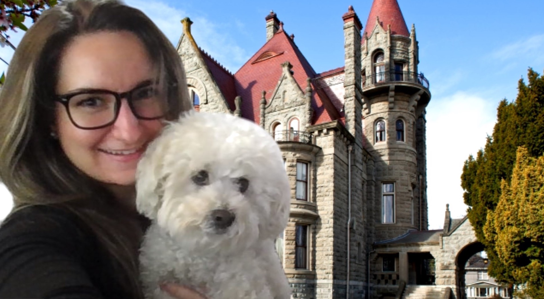 Une femme pose avec son chien devant un château.